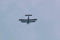 A Biplane flying over the site
